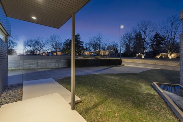 yard at dusk featuring a patio area