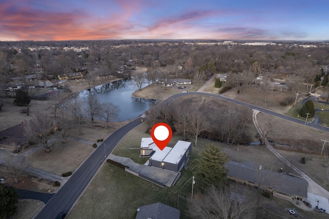 aerial view at dusk featuring a water view