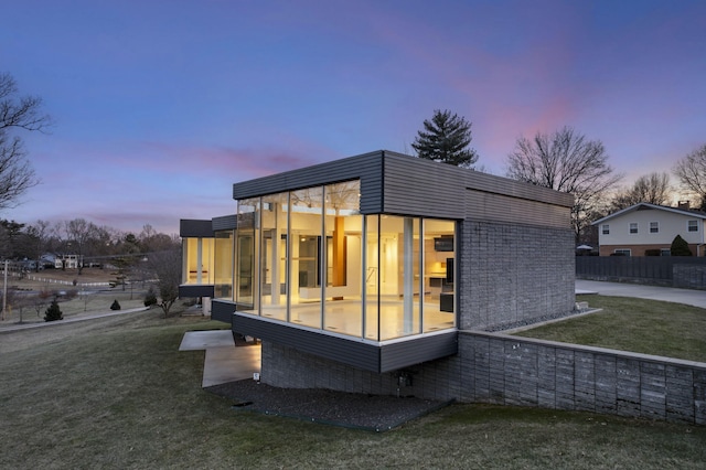 property exterior at dusk with a yard