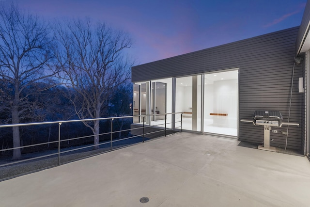 patio terrace at dusk featuring a balcony