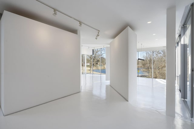 corridor with floor to ceiling windows and track lighting