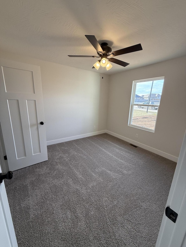 carpeted empty room featuring ceiling fan and a textured ceiling