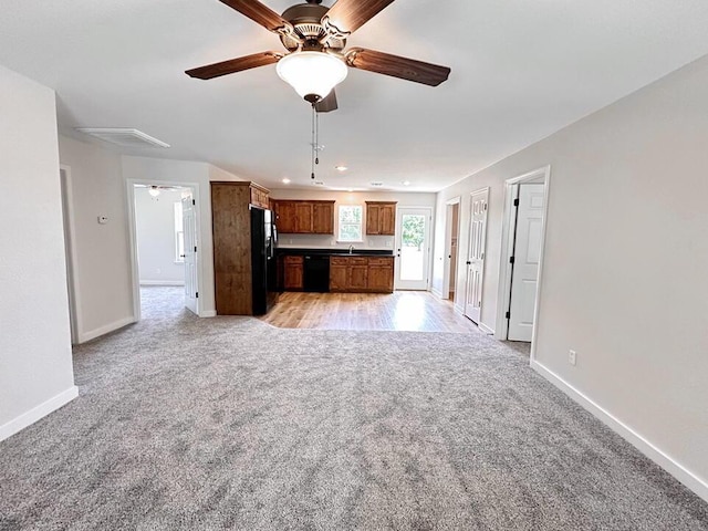 unfurnished living room featuring light carpet and ceiling fan