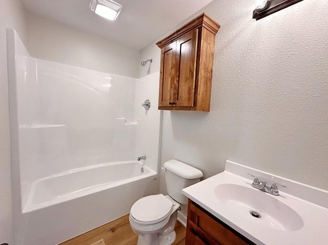 full bathroom with vanity, hardwood / wood-style flooring, shower / tub combination, and toilet