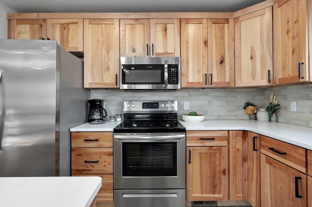 kitchen featuring stainless steel appliances and backsplash