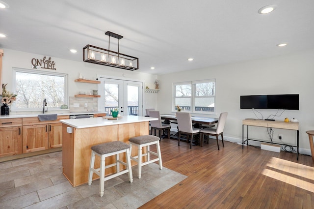 kitchen with a kitchen bar, a center island, a healthy amount of sunlight, and french doors