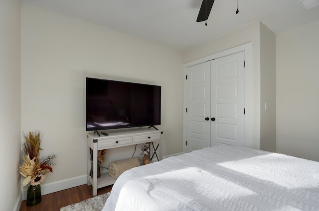 bedroom with dark hardwood / wood-style floors, a closet, and ceiling fan