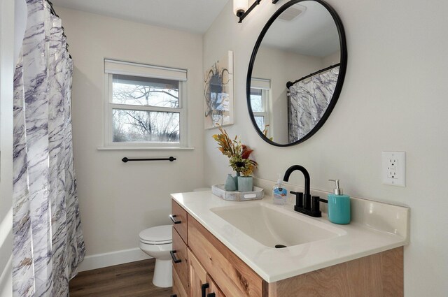 bathroom featuring vanity, hardwood / wood-style floors, and toilet