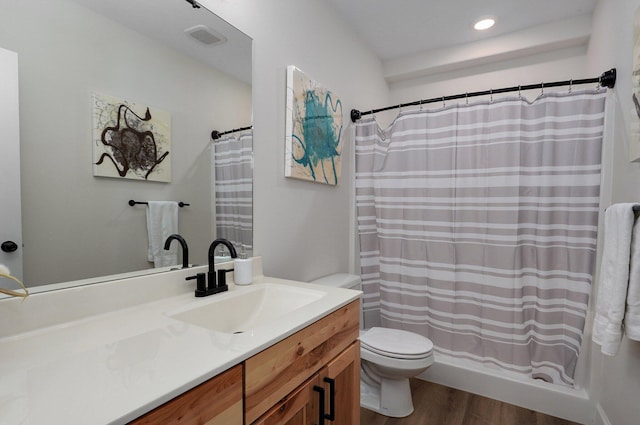 bathroom featuring hardwood / wood-style flooring, vanity, toilet, and walk in shower