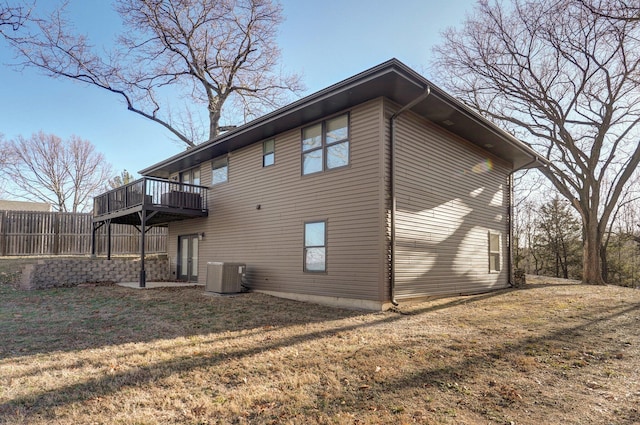 back of house with a yard, a deck, and central air condition unit