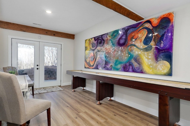 interior space with french doors, beamed ceiling, and light wood-type flooring