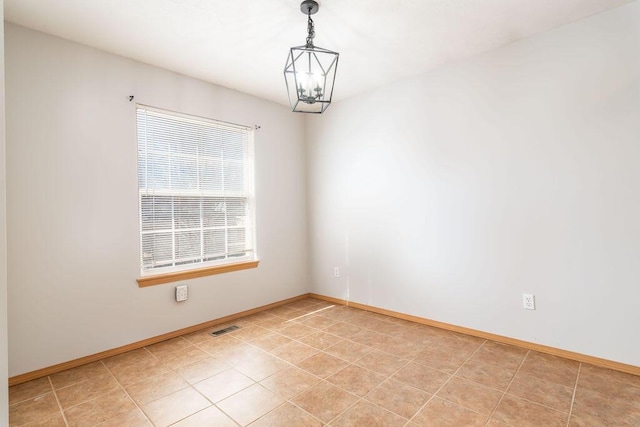 unfurnished room featuring a notable chandelier and light tile patterned floors