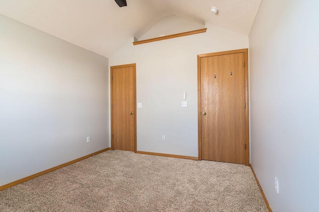 empty room featuring vaulted ceiling and carpet floors