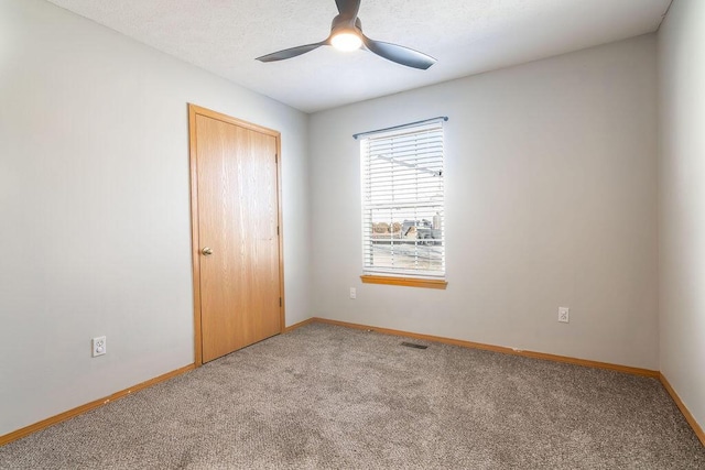 carpeted spare room featuring ceiling fan