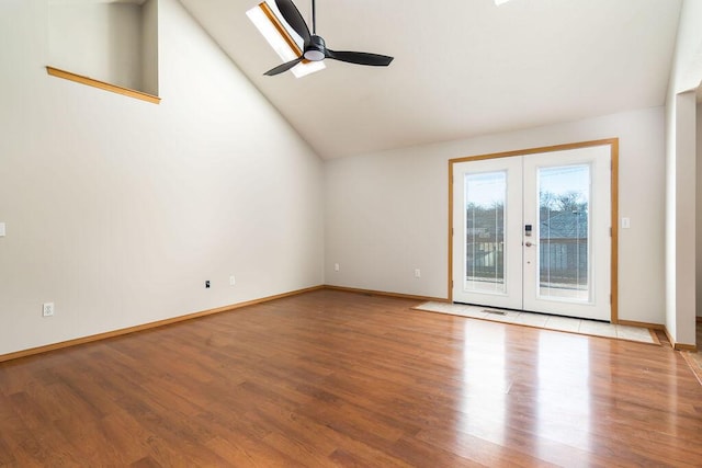 interior space with french doors, ceiling fan, vaulted ceiling, and light wood-type flooring