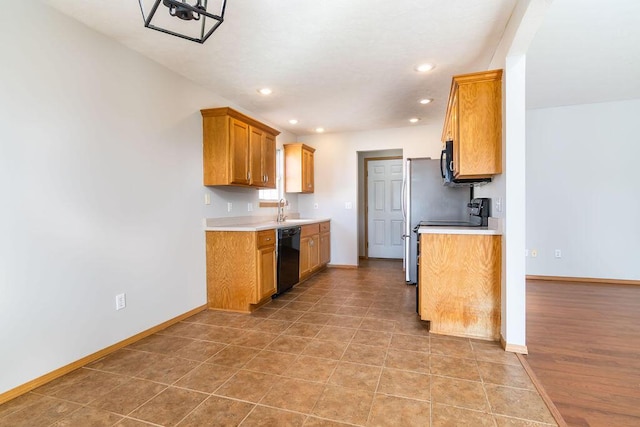 kitchen with sink, light tile patterned floors, and black appliances