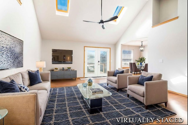 living room with dark wood-type flooring, a skylight, high vaulted ceiling, and ceiling fan