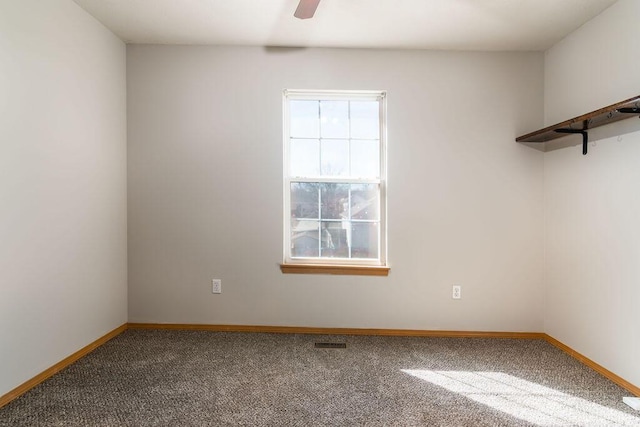 carpeted spare room featuring ceiling fan