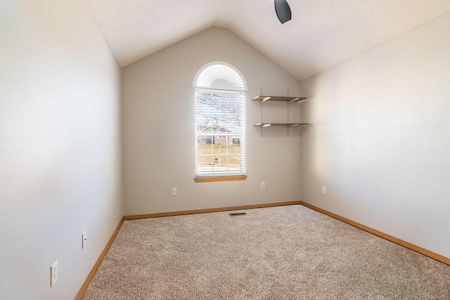 unfurnished room featuring carpet flooring and vaulted ceiling