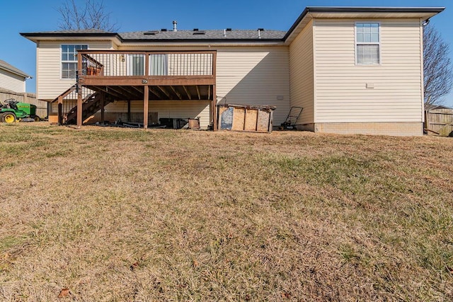 back of property featuring a wooden deck and a lawn