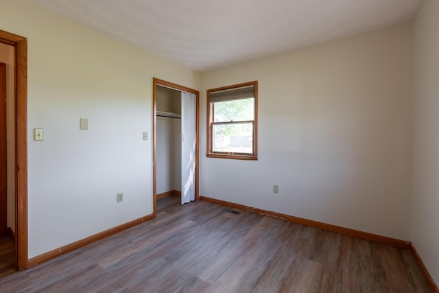 unfurnished bedroom with a closet and light wood-type flooring