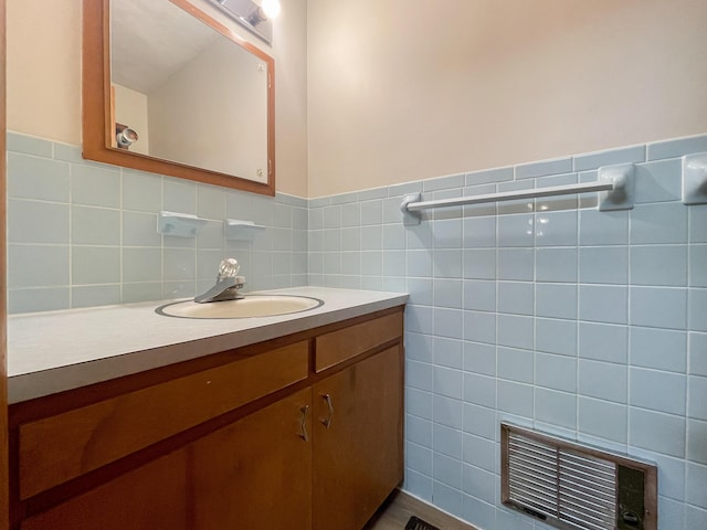 bathroom with vanity and tile walls