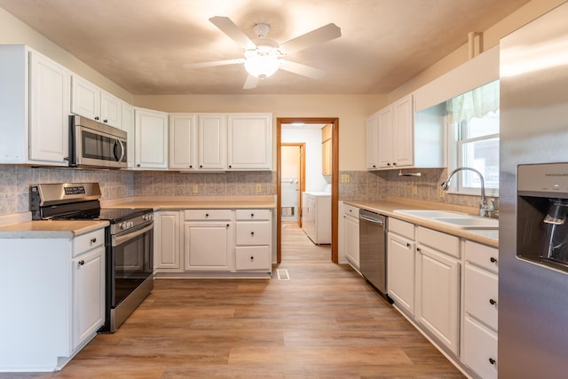 kitchen with white cabinetry, stainless steel appliances, light hardwood / wood-style floors, and sink