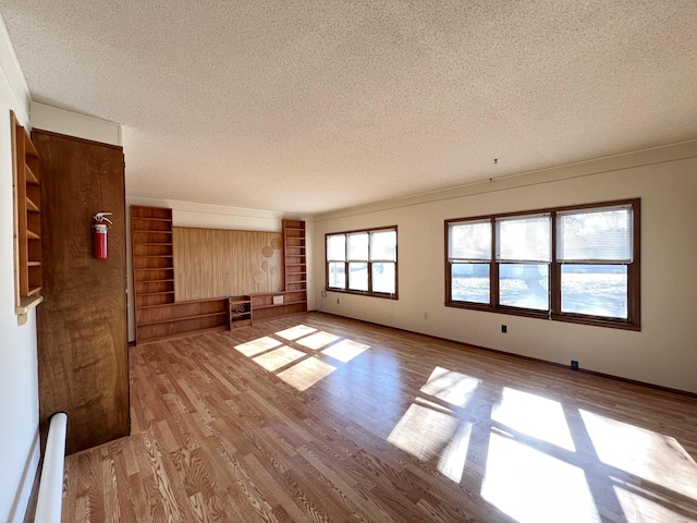 unfurnished living room featuring a textured ceiling and light wood-type flooring