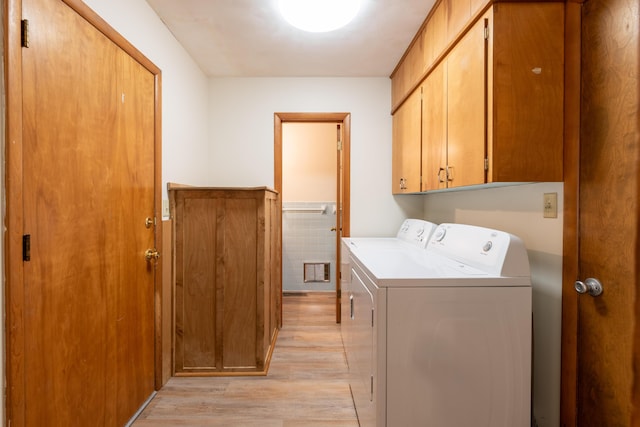 laundry area with cabinets, tile walls, independent washer and dryer, and light hardwood / wood-style floors