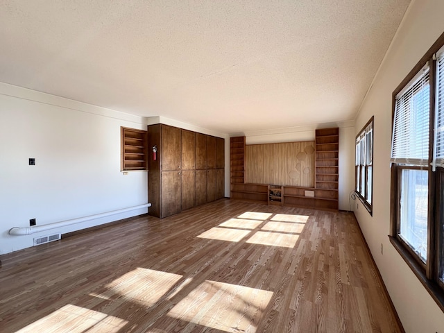 unfurnished living room featuring dark hardwood / wood-style flooring and a textured ceiling