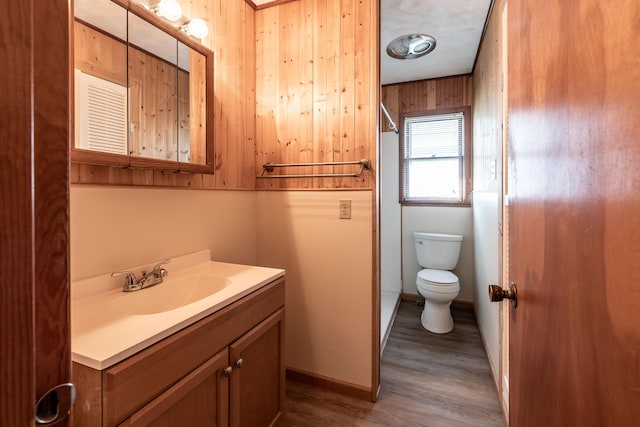 bathroom with vanity, hardwood / wood-style flooring, toilet, and wood walls