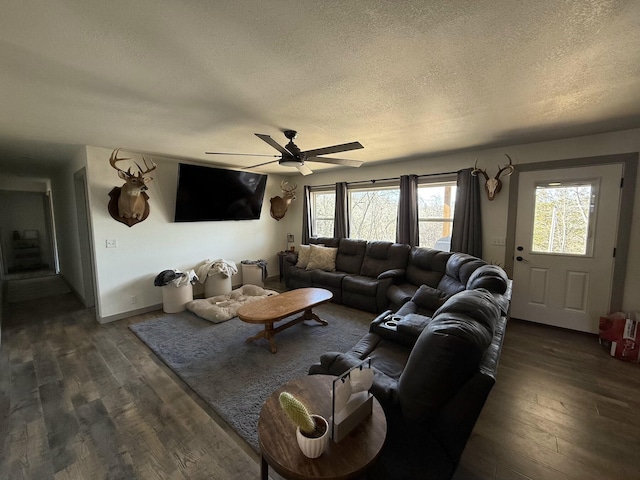 living room with ceiling fan, a textured ceiling, and dark hardwood / wood-style flooring