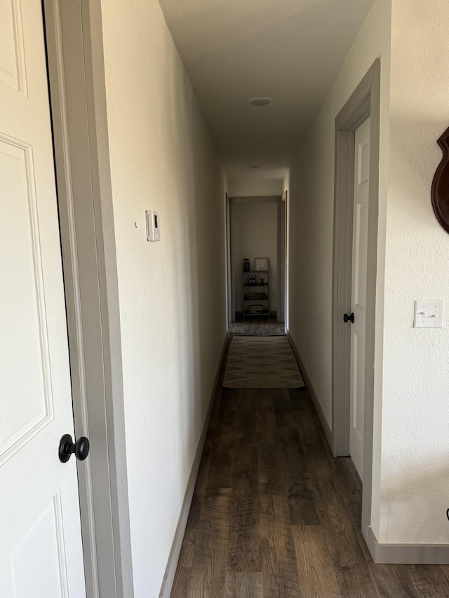 hallway with dark hardwood / wood-style flooring