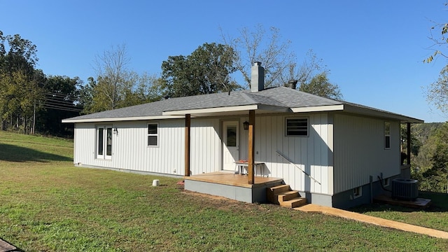 view of front of home with central AC unit and a front yard