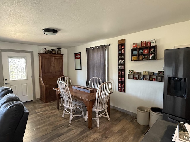 dining space with dark hardwood / wood-style floors and a textured ceiling