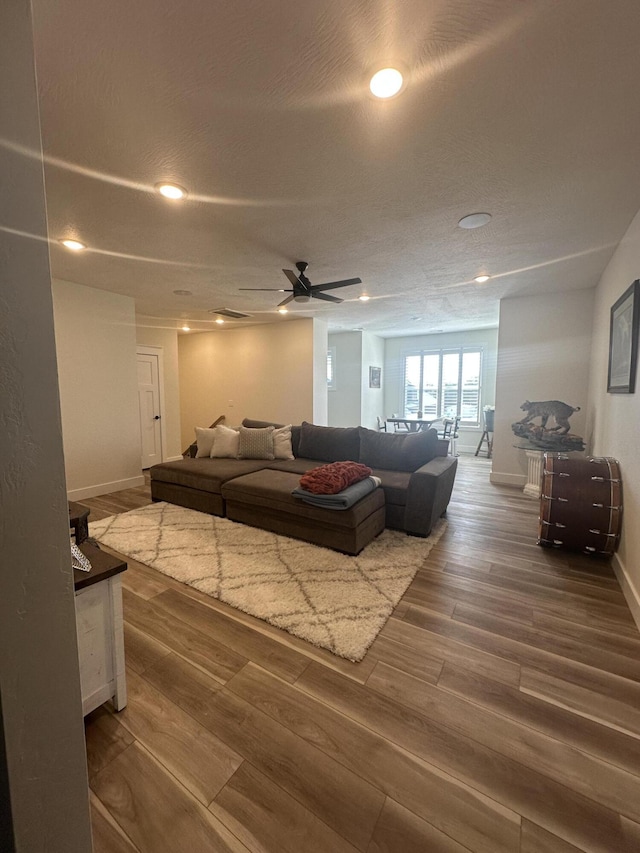 living room featuring dark hardwood / wood-style flooring and ceiling fan