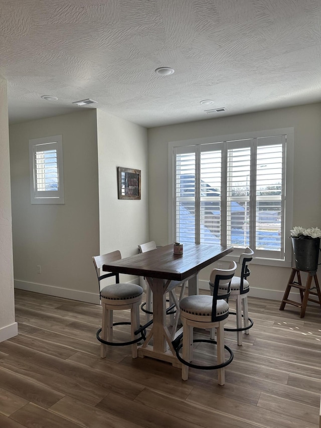 dining room featuring hardwood / wood-style floors and a textured ceiling