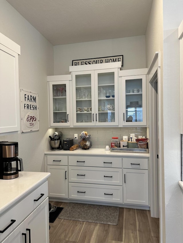 interior space with dark hardwood / wood-style floors, white cabinets, and backsplash