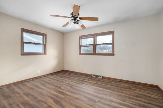 empty room featuring dark wood-type flooring and ceiling fan