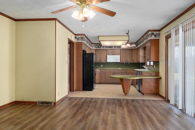 kitchen with sink, light wood-type flooring, black refrigerator, ornamental molding, and ceiling fan