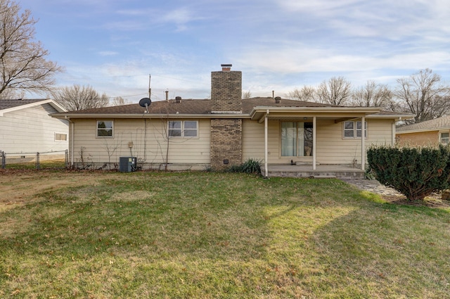 rear view of property with cooling unit and a yard