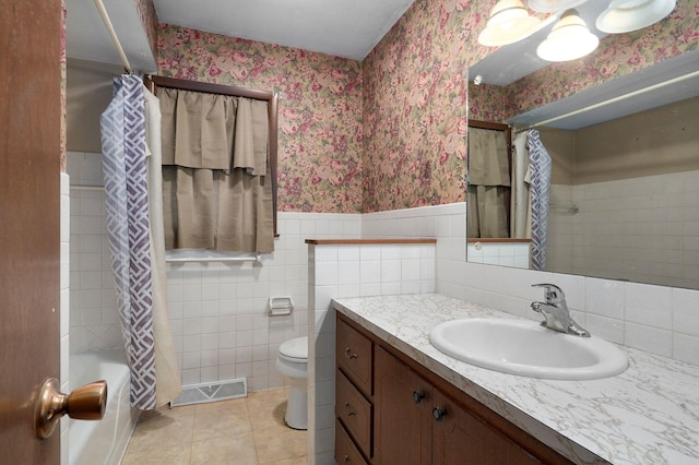 full bathroom with tile patterned flooring, shower / tub combo, tile walls, vanity, and toilet