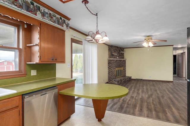 kitchen featuring hanging light fixtures, stainless steel dishwasher, ornamental molding, a fireplace, and ceiling fan with notable chandelier