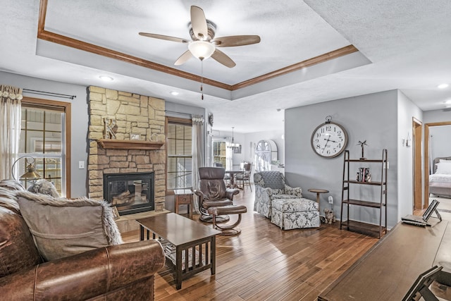 living room featuring a tray ceiling, hardwood / wood-style floors, and a textured ceiling