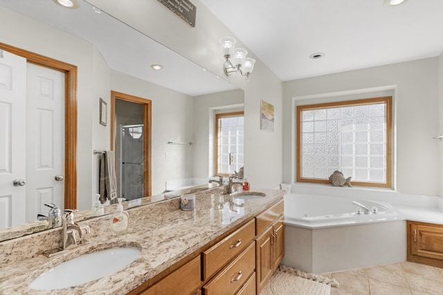 bathroom with tile patterned floors, a bathing tub, and vanity