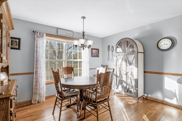 dining area with a chandelier and light hardwood / wood-style floors