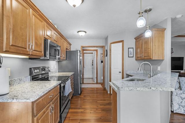 kitchen featuring sink, dark hardwood / wood-style floors, pendant lighting, stainless steel appliances, and light stone countertops