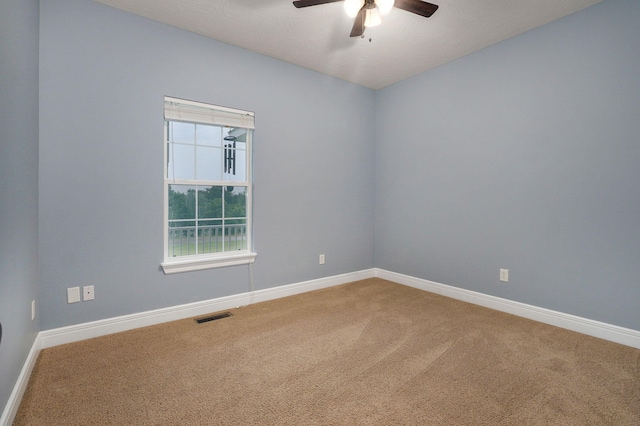 carpeted spare room featuring ceiling fan