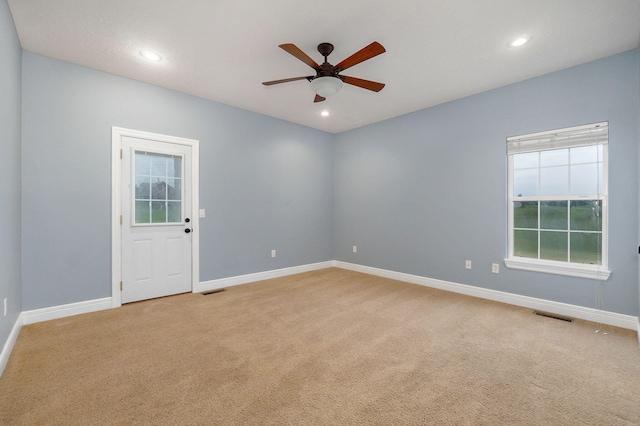 spare room with light carpet and ceiling fan