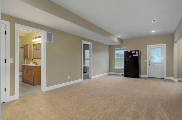 unfurnished living room featuring light carpet